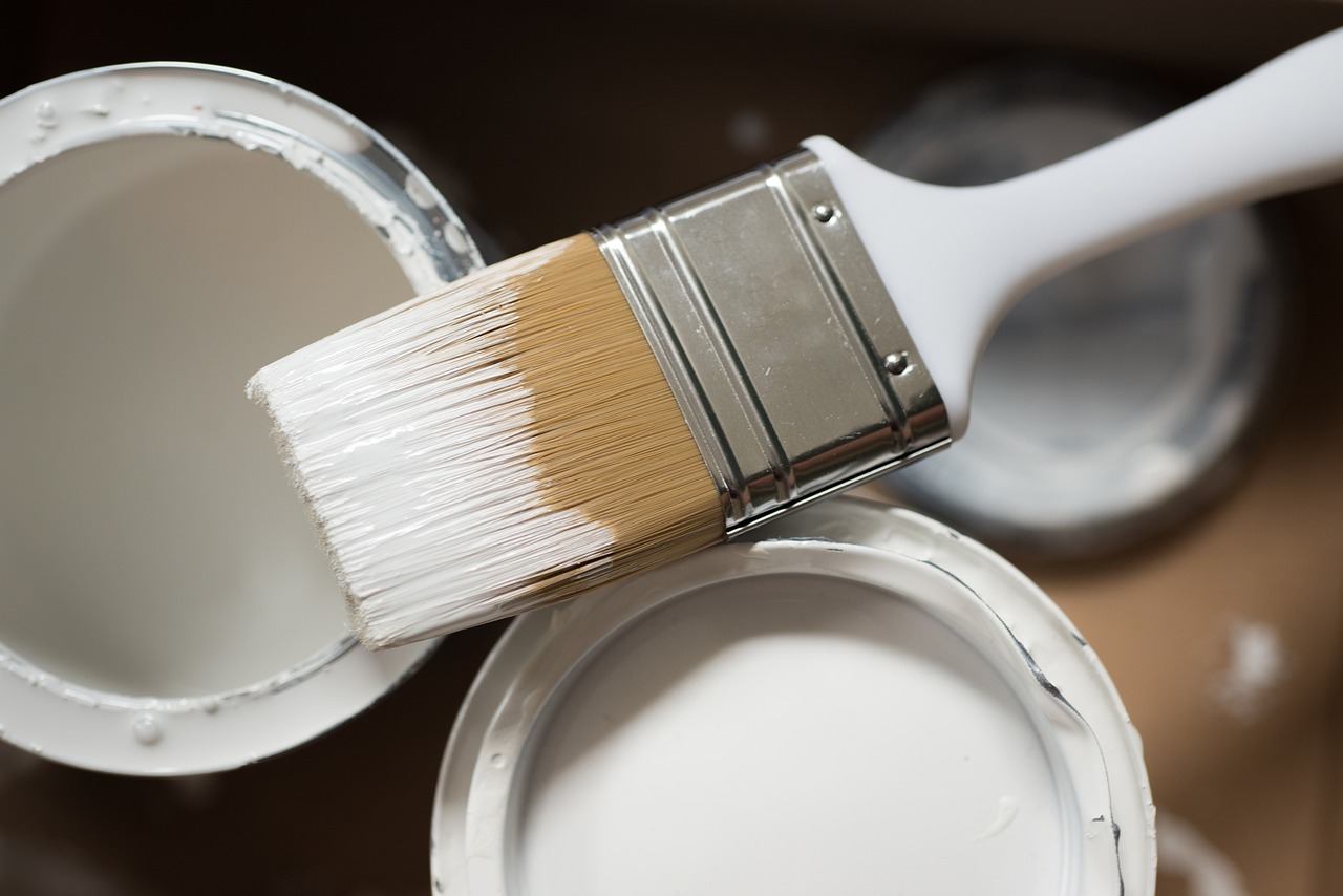 paint brush and white paint tin cans