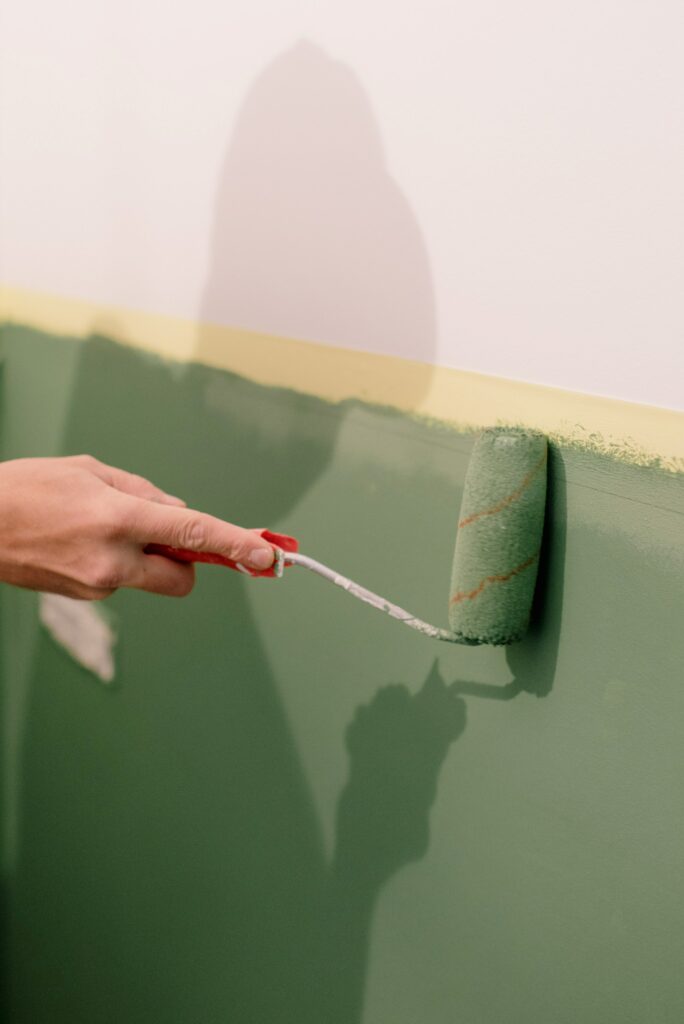 painting a wall green with a roller brush