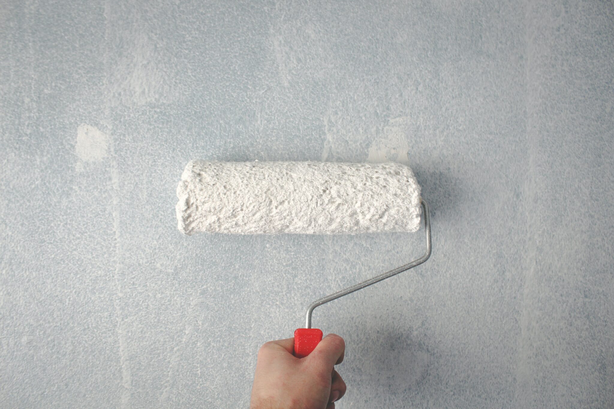 Roller brush painting a wall